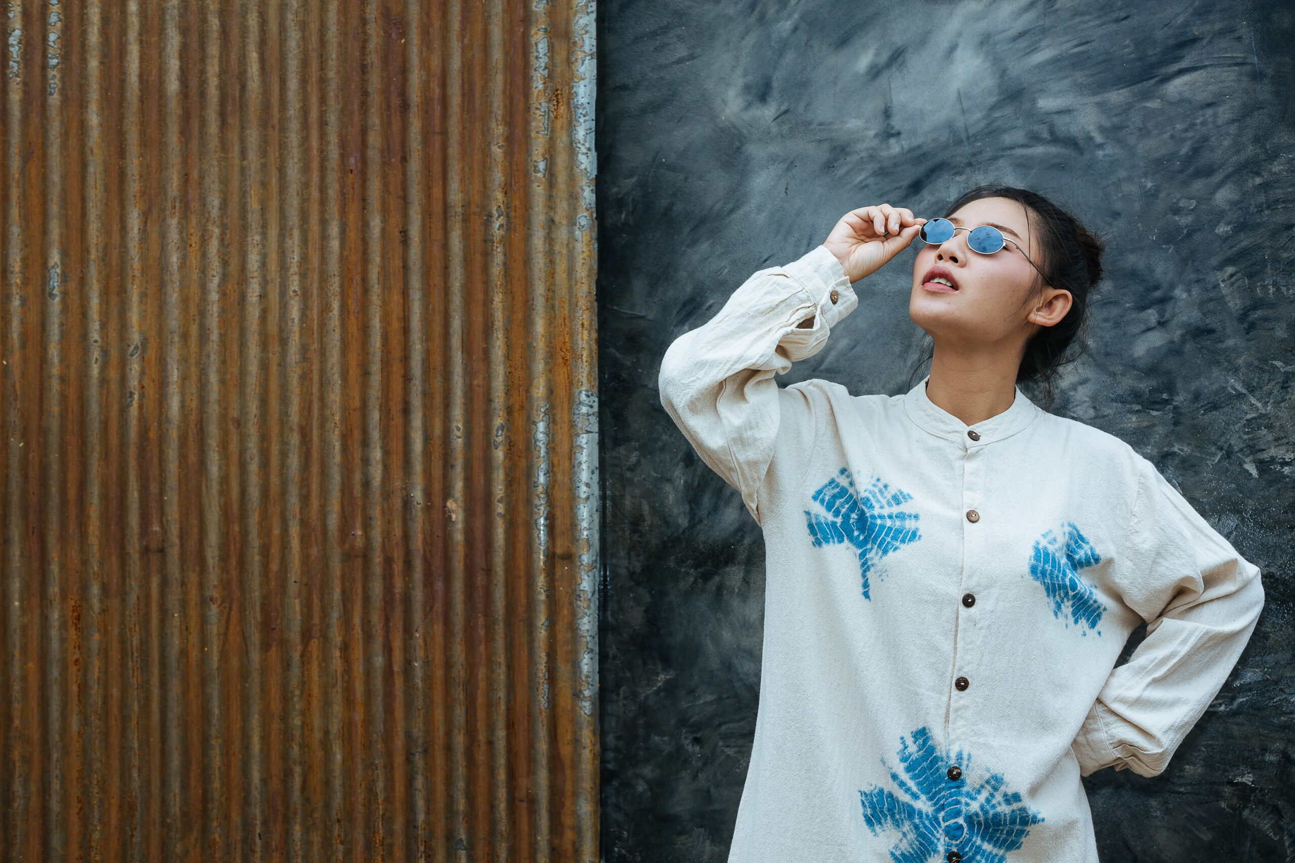 the woman wearing glasses stands to show that the background is